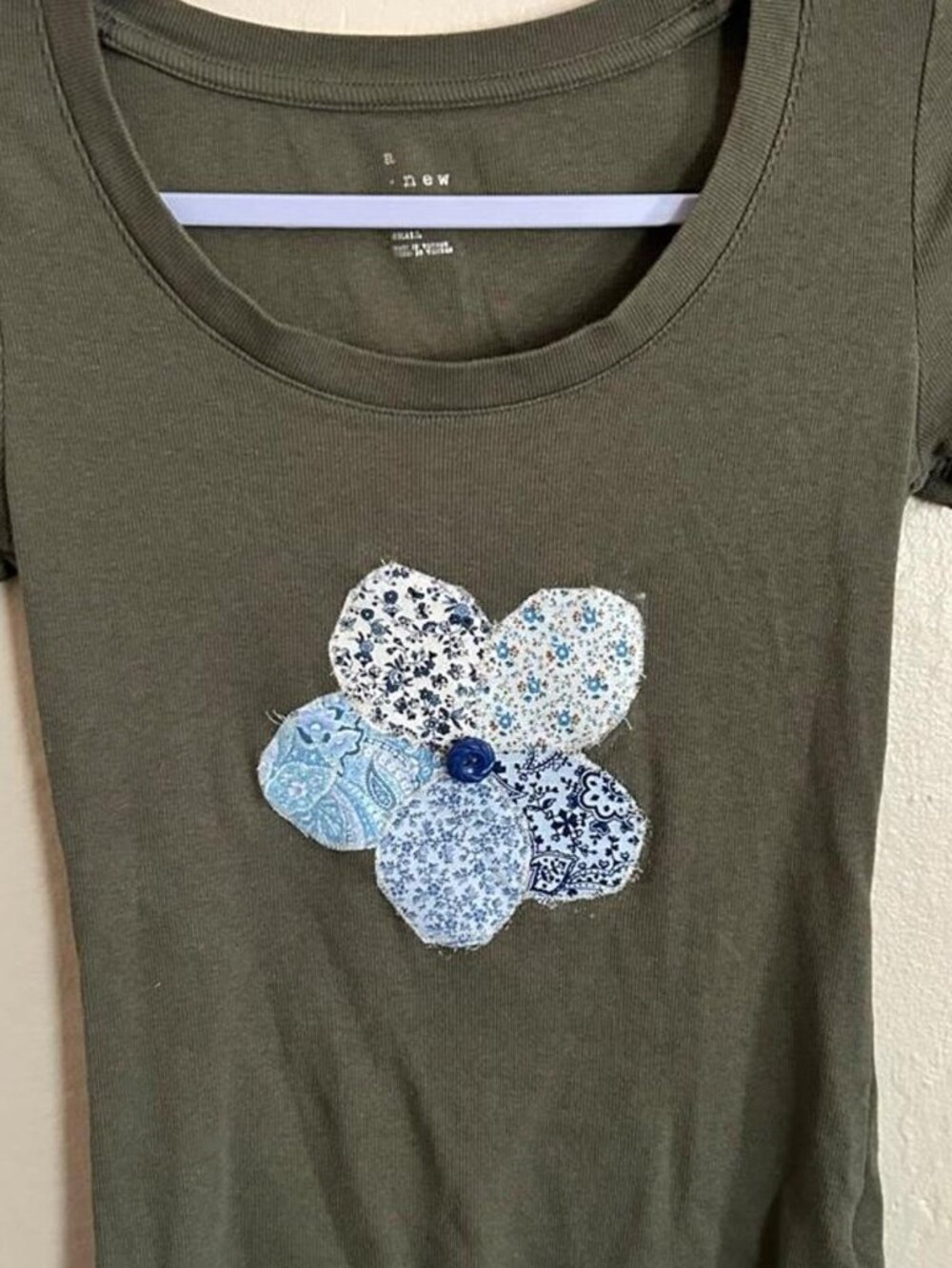Soft olive sweatshirt with handmade white floral patches and vintage button